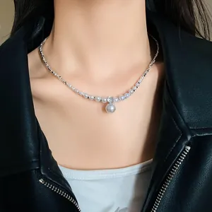 Detail of a French style faux pearl and zircon pendant necklace worn by a model
