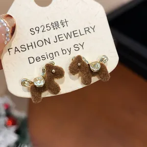 Detailed view of brown flocked horse stud earrings with elegant gold accents on card