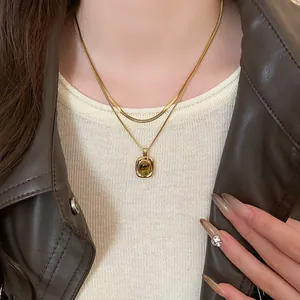 Primo piano di una collana a due strati in occhio di tigre dorato con giacca di pelle