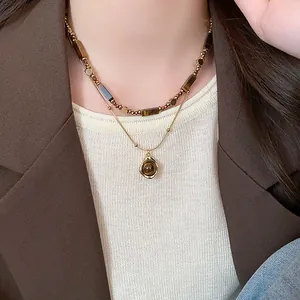 Dettaglio di una collana a doppio strato placcata in oro con perle occhio di tigre