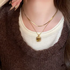 Primo piano di una collana placcata in oro con ciondolo in pietra occhio di tigre