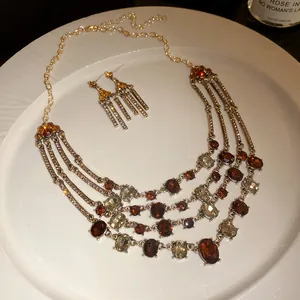 Vintage multi-layer oval rhinestone necklace and matching earring set on a white plate