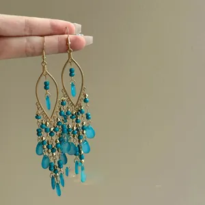 Handheld Bohemian gold tassel earrings with blue glass beads and waterdrop charms