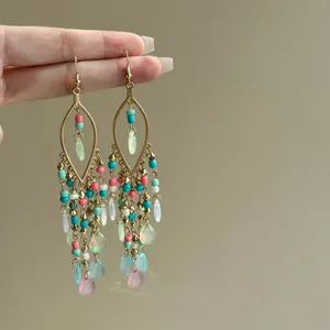 Detailed view of bohemian dangle earrings with colorful glass beads and teardrop pendants