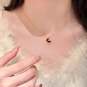 Magnifique collier plaqué or avec pendentif cheval à bascule rouge et gourde en zircone
