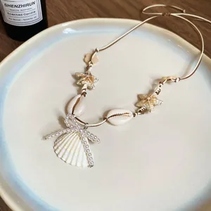 Detailansicht einer Halskette mit Muscheln, Seesternen und einer Perlen-Schleife.