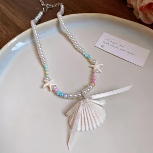 Nahaufnahme einer Muschelkette mit Perlen, Seesternen und pastellfarbenen Perlen.