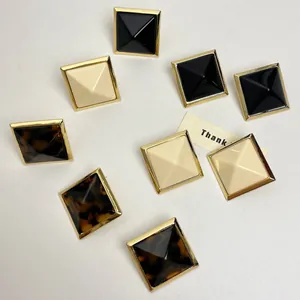Detailed overhead view of pyramid resin stud earrings in black, cream, and tortoiseshell