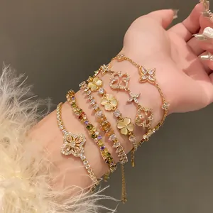 Detailed macro view of stacked zircon flower bracelets with an elegant golden finish on wrist