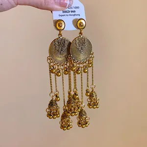 Detailed view of ethnic gold tassel earrings with 925 silver needle on price tag
