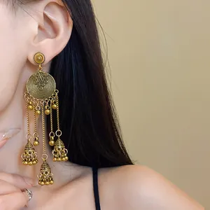 Detail shot of vintage ethnic style dangling earrings with gold tassels and bells.