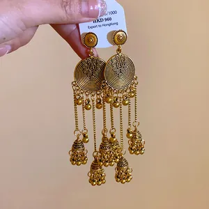 Macro view of ethnic style golden tassel earrings with circular motifs and bells