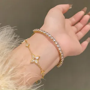 Detailed view of luxury gold-tone flower bracelet and shimmering zircon tennis bangle