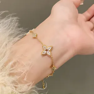 Close-up detail of an elegant gold-tone bracelet featuring zircon flower and water-drop petals
