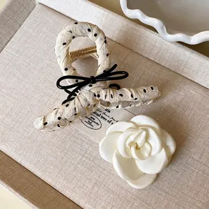 Polka dot fabric wrapped hair claw clip with black bow and camellia flower accessory