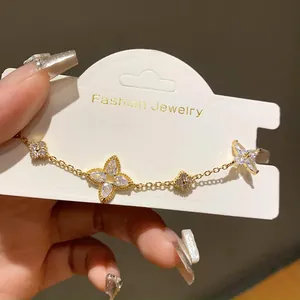 Detailed macro shot of gold flower bracelet with clear zircons on a white display card