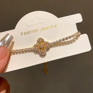 Detailed view of a gold-plated flower bracelet featuring peach zircon and pavé stones.