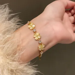 Detailed view of an elegant gold-plated flower bracelet with zircons and cat eye stones.