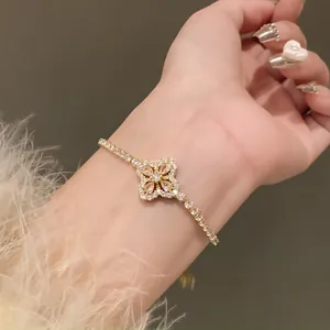 Close-up of gold-plated bracelet featuring zircon flower motif with teardrop stones.