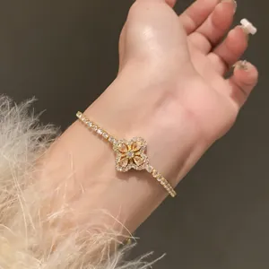 Macro detail of an elegant gold flower bracelet featuring sparkling peach cubic zirconia