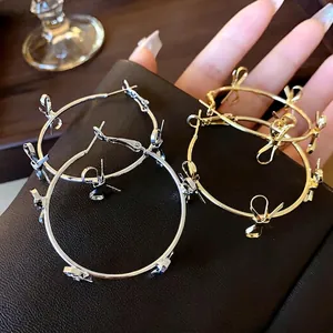 Eleganti orecchini a cerchio grandi in oro e argento con ciondoli a fiocco per donna