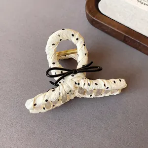 Close-up of a French style polka dot fabric wrapped hair claw clip with a bow