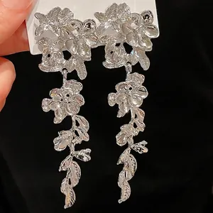 Elegant silver-colored metal floral tassel earrings with intricate textures and long drops.