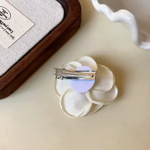 Detailed back view of a white camellia flower hair clip with metal alligator clip