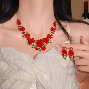 Detail showing red rose necklace with pearls and crystals on a model's neck.