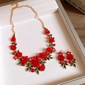 Elegant red resin rose and green leaf jewelry set with necklace and matching earrings