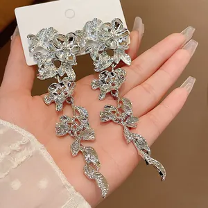 Detailed macro shot of silver floral tassel earrings showing intricate metal texture.