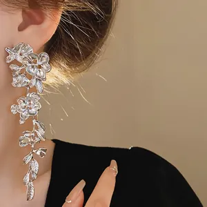 Macro view of silver metallic floral tassel earrings on a model ear for detail