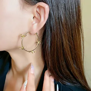 Grandi orecchini a cerchio dorati con eleganti decorazioni a fiocco per ragazze