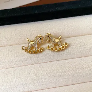Detailed macro shot of gold-plated rocking horse stud earrings with sparkling pavé crystals