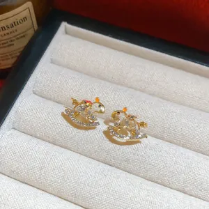 Detailed view of elegant rocking horse stud earrings featuring sparkling crystals and gold finish