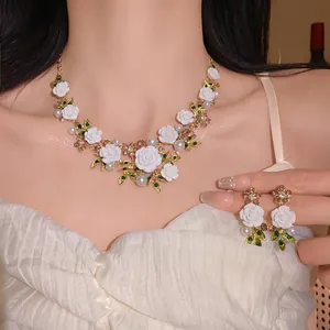 Elegant close-up detail of white rose and leaf necklace with pearls and rhinestones