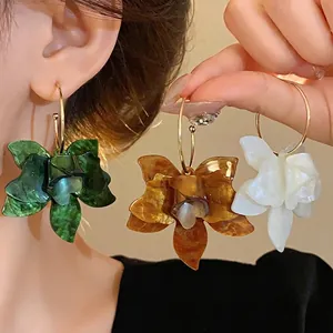Vintage resin flower hoop earrings in green, amber, and white for a chic look.