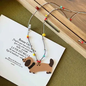 Handmade wax cord necklace with a cute acrylic dachshund dog pendant and colorful beads.