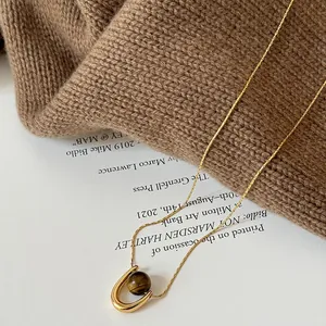 Elegant gold stainless steel U-shape necklace featuring a natural tiger eye stone bead