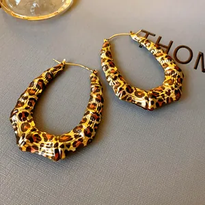 Close-up of retro U-shaped bamboo hoop earrings with trendy leopard print patterns