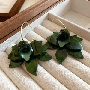 Close-up of dark green resin flower earrings featuring delicate petal details.