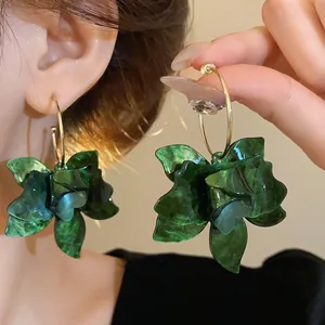 Detailed close-up macro shot of vintage dark green resin flower petal hoop earrings