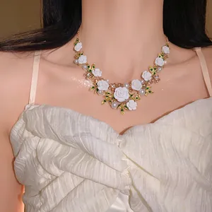 Detailed view of a sweet floral and leaf necklace with pearls and rhinestones on a model