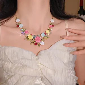 Close-up detail of floral leaf necklace with colorful pearls and rhinestones on model