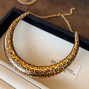 Close-up of the oversized U-shaped leopard print collar necklace in a jewelry tray.