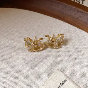 Elegant golden rocking horse stud earrings with sparkling cubic zirconia.