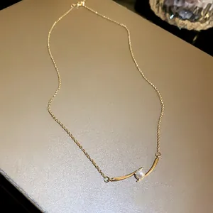 Detailed view of French pearl geometric necklace with elegant gold curved pendant