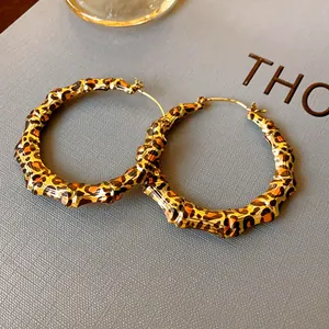 Detail view of bold leopard print bamboo texture hoop earrings with gold-tone hardware