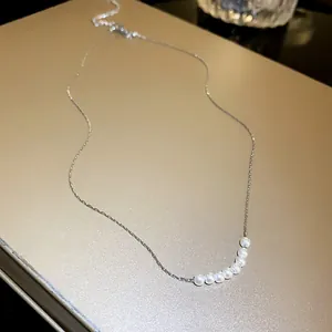Detail shot of elegant mermaid pearl necklace with seven pearls on silver chain