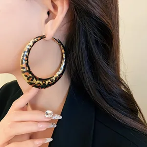 Stunning close-up view of a large leopard print U-shape hoop earring on a model